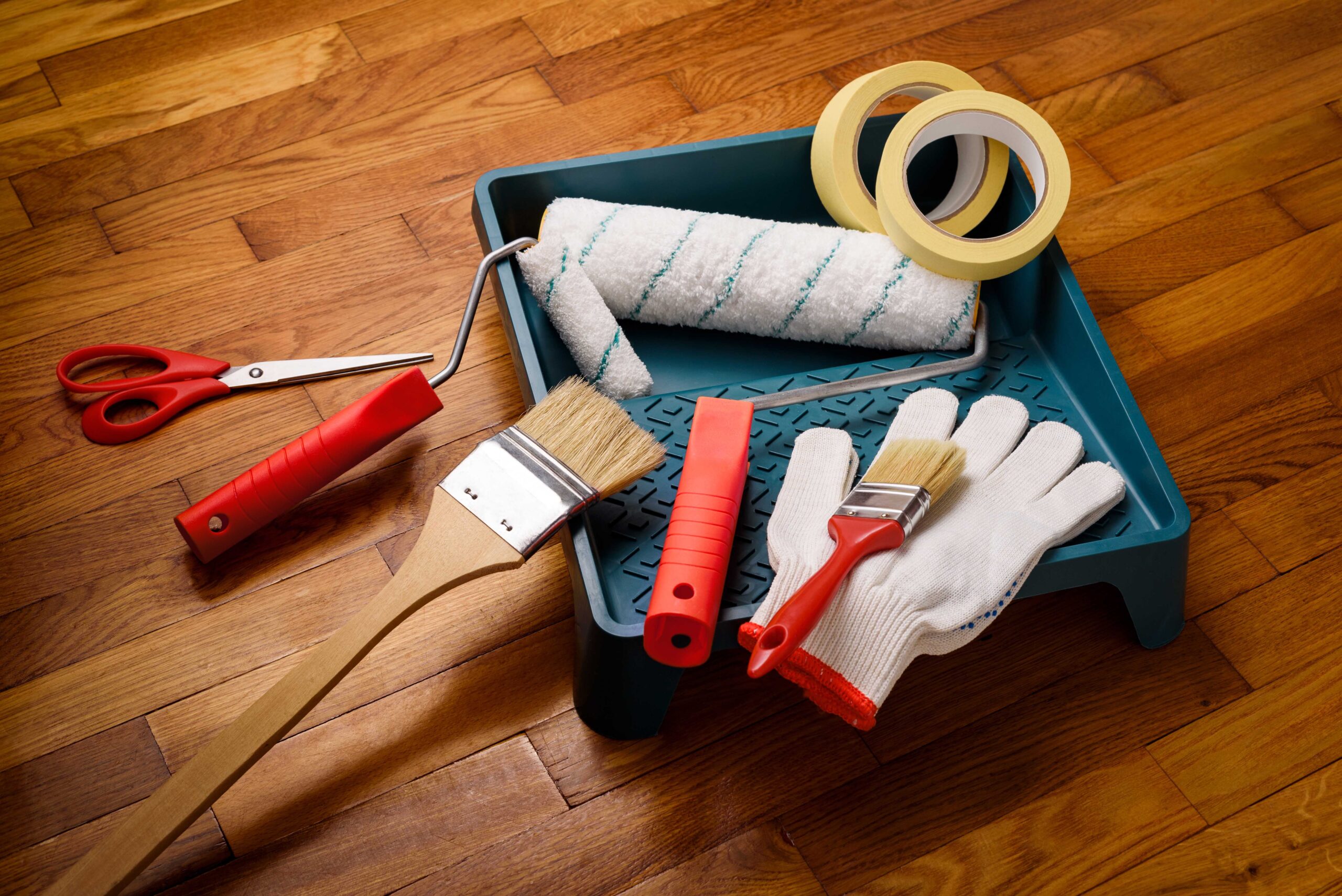 Set of tools for painting walls at home: painter's tape, gloves, scissors, paint rollers and tray, brush