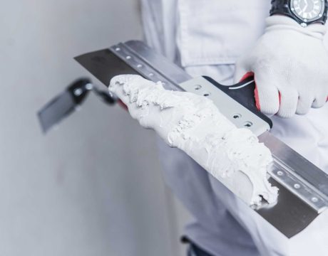 Preparing For Drywall Patch. Patching Tools in Hand of Worker Closeup Photo
