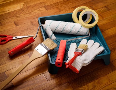 Set of tools for painting walls at home: painter's tape, gloves, scissors, paint rollers and tray, brush